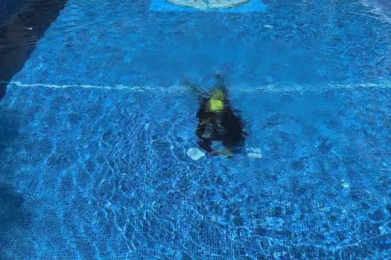 Buzo de OK Fugas de Agua inspeccionando el vaso de una piscina bajo el agua